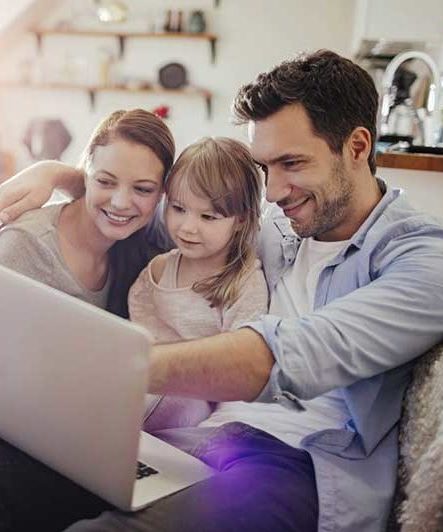 Family At Home with child looking at laptop 